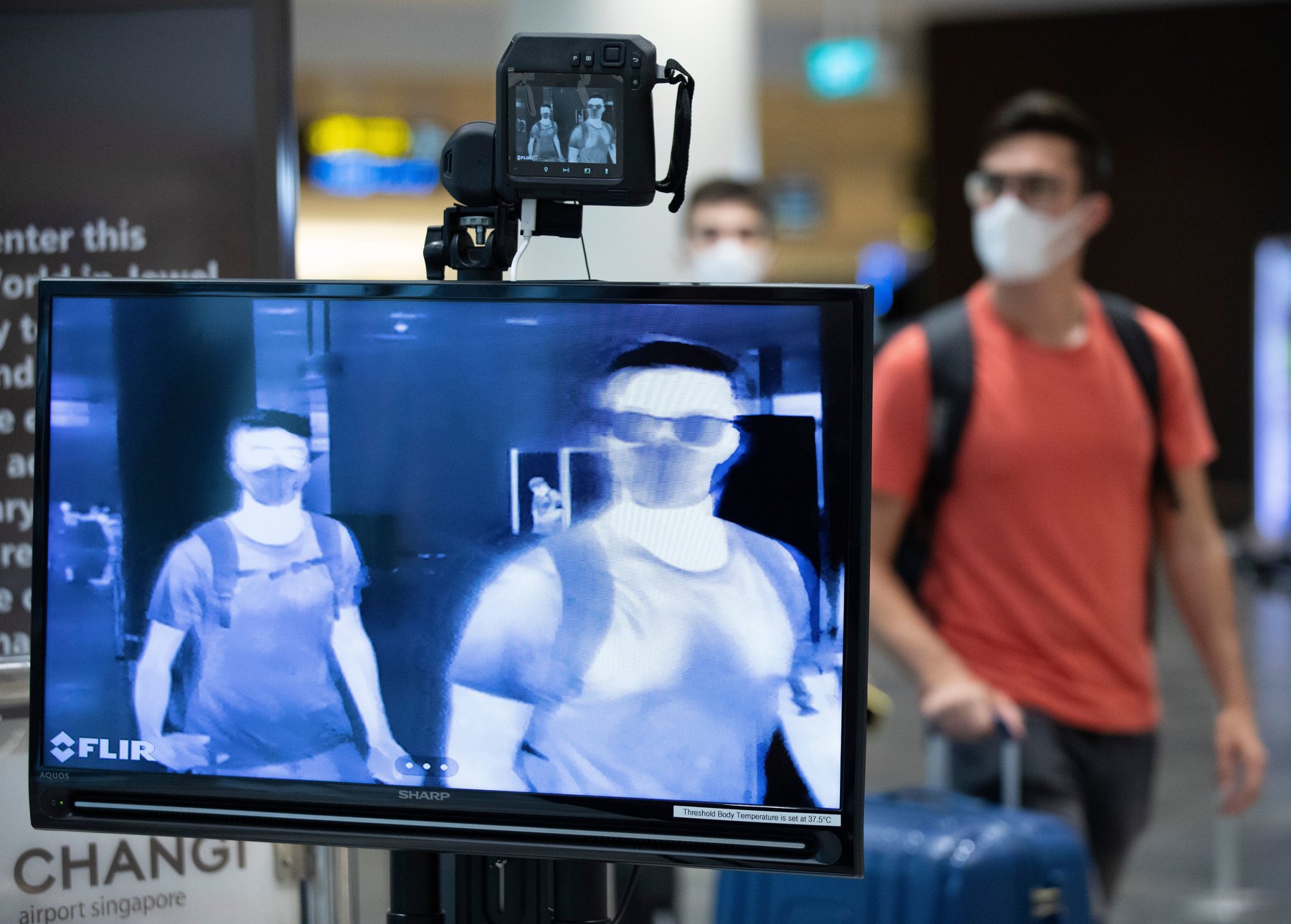 Thermal camera screen showing the skin temperature of travellers walking through an airport