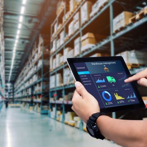 Warehouse manager using a tablet inventory dashboard between racks
