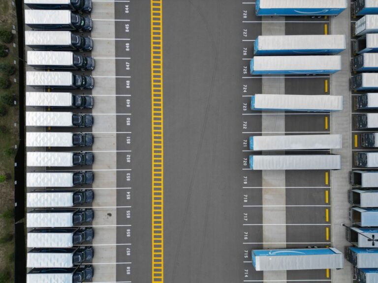 Top-down view of trucks lined up in a logistics yard waiting their turn
