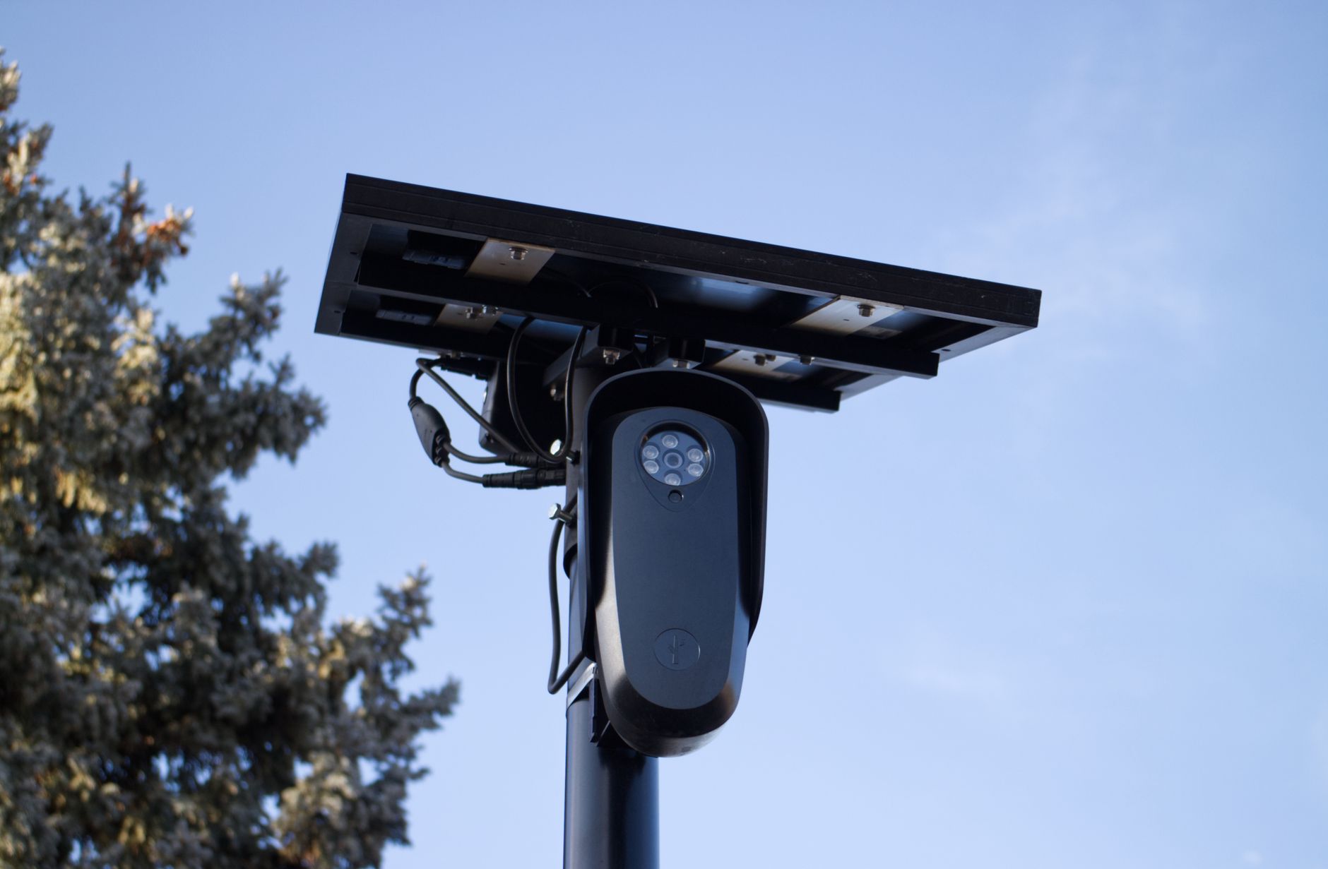 Camera beside a boom barrier used for number plate recognition in a gate lane